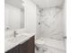 Bathroom features wood cabinets, quartz countertop, marble-look tile shower and floors and modern fixtures at 24259 Peppercorn Rd, Punta Gorda, FL 33955