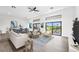 Bright living room with contemporary furnishings, high ceilings, and seamless indoor-outdoor flow to a covered patio at 24259 Peppercorn Rd, Punta Gorda, FL 33955