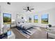 Bright main bedroom features a ceiling fan, accent rug and three windows overlooking a green lawn at 24259 Peppercorn Rd, Punta Gorda, FL 33955