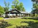 Spacious community picnic area features multiple covered pavilions and picnic tables surrounded by lush green grass at 24259 Peppercorn Rd, Punta Gorda, FL 33955