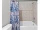 A clean bathroom featuring a shower/tub combo with a patterned shower curtain and tiled walls at 25336 Deep Creek Blvd, Punta Gorda, FL 33983