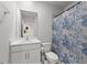 Well-lit bathroom with a vanity, toilet, and a shower/tub combo with a patterned curtain at 25336 Deep Creek Blvd, Punta Gorda, FL 33983