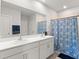 Bright bathroom featuring dual sinks, a shower with a patterned curtain, and modern fixtures at 25336 Deep Creek Blvd, Punta Gorda, FL 33983