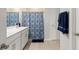 Modern bathroom with double sinks and a shower featuring a patterned curtain at 25336 Deep Creek Blvd, Punta Gorda, FL 33983