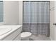 A clean bathroom with a shower featuring a patterned curtain and simple decor at 25336 Deep Creek Blvd, Punta Gorda, FL 33983