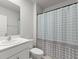 Well-lit bathroom with a single sink vanity and a shower with a patterned curtain at 25336 Deep Creek Blvd, Punta Gorda, FL 33983