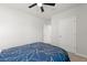 Spacious bedroom featuring a ceiling fan, a navy blue bedspread, and multiple doors at 25336 Deep Creek Blvd, Punta Gorda, FL 33983