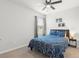 Inviting bedroom showcasing a ceiling fan, a navy blue bedspread, and neutral walls at 25336 Deep Creek Blvd, Punta Gorda, FL 33983