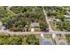 Aerial view of a single-Gathering home on a tree-lined lot with clearly defined property lines and a charming shed at 2631 Tomaso Rd, North Port, FL 34287