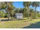 Wide shot of the backyard showing the storage shed with surrounding trees at 2631 Tomaso Rd, North Port, FL 34287