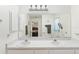 Bright bathroom featuring double sinks, a large mirror and view of bedroom at 2631 Tomaso Rd, North Port, FL 34287