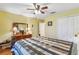 Bright bedroom featuring a ceiling fan, closet, and a dresser with a decorative mirror at 2631 Tomaso Rd, North Port, FL 34287