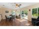 Bright dining area with hardwood floors, a ceiling fan, and glass doors to the backyard at 2631 Tomaso Rd, North Port, FL 34287