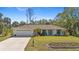 Charming single-story home with a well-manicured lawn and a two-car garage showcasing curb appeal at 2631 Tomaso Rd, North Port, FL 34287