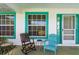 Cozy front porch with seating, colorful trim, and ample natural light, providing a relaxing outdoor space at 2631 Tomaso Rd, North Port, FL 34287