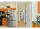 Functional kitchen featuring stainless steel fridge and convenient access to hallway and appliances at 2631 Tomaso Rd, North Port, FL 34287