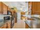 Functional kitchen with wooden cabinets, black appliances, and tile flooring, providing ample counter space at 2631 Tomaso Rd, North Port, FL 34287