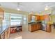 Sunlit kitchen featuring traditional wood cabinets, stainless steel appliances, and a cozy breakfast nook at 2631 Tomaso Rd, North Port, FL 34287