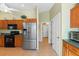 Bright kitchen featuring wood cabinets, stainless steel refrigerator, and convenient access to hallway at 2631 Tomaso Rd, North Port, FL 34287