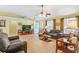 Bright living room with large windows, tile flooring, and a ceiling fan, offering a comfortable and inviting space at 2631 Tomaso Rd, North Port, FL 34287