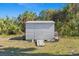 Outdoor gray storage shed with a ramp in a grassy backyard at 2631 Tomaso Rd, North Port, FL 34287