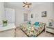 Bright bedroom features a colorful bedspread and nautical decor under a ceiling fan at 2917 Mill Creek Rd, Port Charlotte, FL 33953