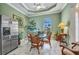Bright dining area features a glass table, stainless fridge, and decorative plants at 2917 Mill Creek Rd, Port Charlotte, FL 33953