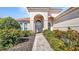 Attractive home entrance with well-maintained landscaping and a brick walkway at 2917 Mill Creek Rd, Port Charlotte, FL 33953