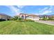 Well-manicured front lawn featuring mature landscaping and a three-car garage at 2917 Mill Creek Rd, Port Charlotte, FL 33953