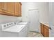Functional laundry room with wood cabinets and a washer and dryer setup at 2917 Mill Creek Rd, Port Charlotte, FL 33953