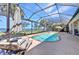 Inviting screened pool area featuring lounge chairs, an umbrella, and stunning water views at 2917 Mill Creek Rd, Port Charlotte, FL 33953