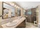 Well-lit bathroom with a double vanity, stone countertop and a glass-enclosed tiled shower at 4279 Harbor Blvd, Port Charlotte, FL 33952