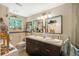 Bright bathroom featuring double sinks, dark cabinetry, and a decorative mirror at 4279 Harbor Blvd, Port Charlotte, FL 33952