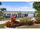 Charming blue home with lush landscaping, covered porch, and a well-manicured lawn at 4279 Harbor Blvd, Port Charlotte, FL 33952