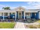Charming blue home featuring a covered front porch with comfortable seating and decorative landscaping at 4279 Harbor Blvd, Port Charlotte, FL 33952