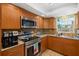 Well-lit kitchen with stainless steel appliances, light brown cabinetry, and tile flooring at 4279 Harbor Blvd, Port Charlotte, FL 33952