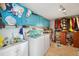 Functional laundry room with blue cabinets, washer, dryer, and storage space at 4279 Harbor Blvd, Port Charlotte, FL 33952