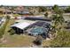 Aerial view of a backyard pool with palms, solar panels and an outdoor living space at 4279 Harbor Blvd, Port Charlotte, FL 33952