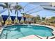 Inviting screened-in pool area with outdoor seating, landscaping and covered patio at 4279 Harbor Blvd, Port Charlotte, FL 33952