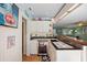 Stylish bar area with a wine fridge, unique tile countertop, and a view of the living room at 6112 Gnarled Oak Dr, Englewood, FL 34223