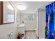 Cozy bathroom with a unique shower curtain, a vanity, and a window for natural light at 6112 Gnarled Oak Dr, Englewood, FL 34223