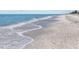 Beautiful beach scene with gentle waves, pristine sand, and clear turquoise waters at 6112 Gnarled Oak Dr, Englewood, FL 34223