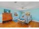 Bright bedroom with hardwood floors, aqua walls, and a view of the outdoors at 6112 Gnarled Oak Dr, Englewood, FL 34223