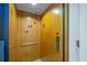 Interior of the residential elevator featuring a wooden panel design with call buttons at 6112 Gnarled Oak Dr, Englewood, FL 34223