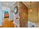 Inviting hallway with a striking brick wall and a decorative mirror at 6112 Gnarled Oak Dr, Englewood, FL 34223