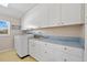 Functional laundry room with ample cabinet space and modern washing machine at 6112 Gnarled Oak Dr, Englewood, FL 34223