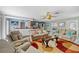 Spacious living room offering ample seating, a stylish rug, and a view of the connected bar area at 6112 Gnarled Oak Dr, Englewood, FL 34223