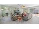 Relaxing living room with comfortable seating, a ceiling fan, and a view of the pool through sliding glass doors at 6112 Gnarled Oak Dr, Englewood, FL 34223