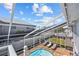 Screened pool with lounge chairs and beautiful sky views at 6112 Gnarled Oak Dr, Englewood, FL 34223