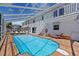Private backyard pool with covered patio and lounge chairs at 6112 Gnarled Oak Dr, Englewood, FL 34223